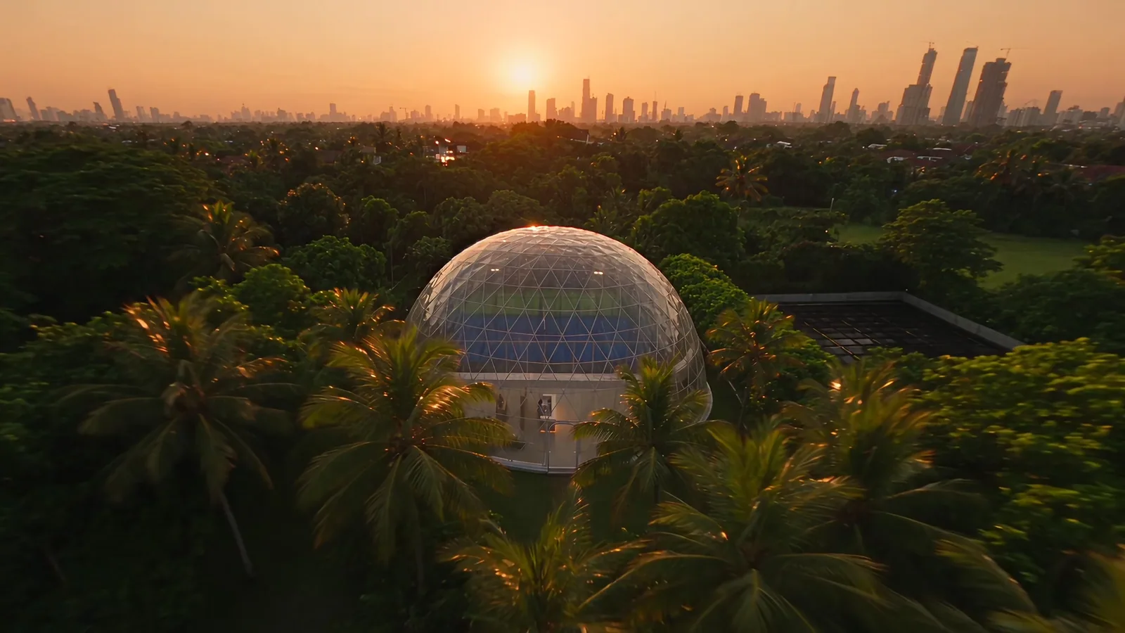 The Padelion glass dome among the palms of Kemang at dusk