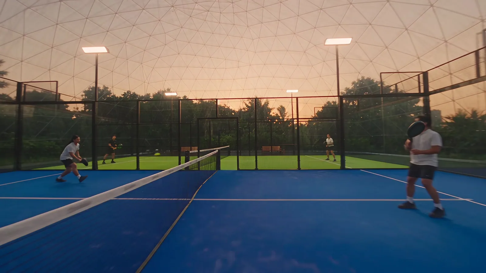 A doubles rally on a blue court